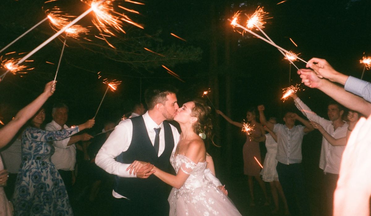 wedding couple kissing at night among fireworks