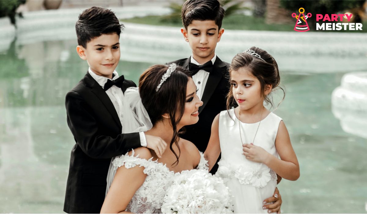 A bride kneeling with a girl and two boys around her