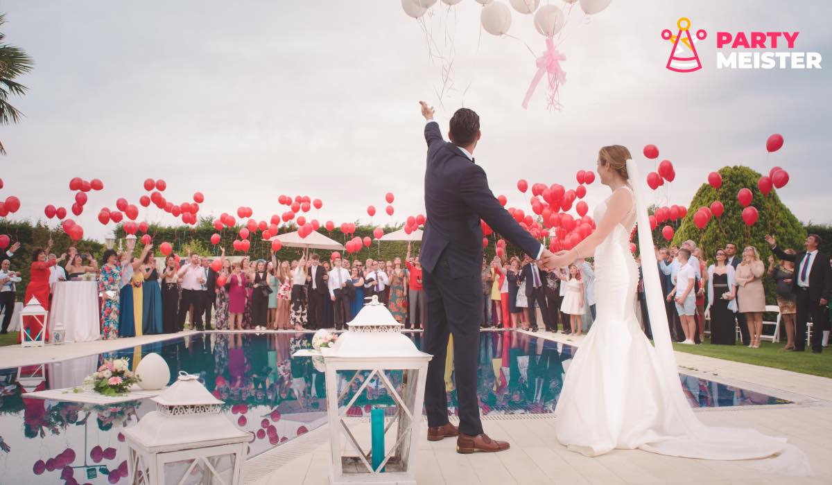 Bride, groom and wedding guests. PartyMeister logo in top-right corner