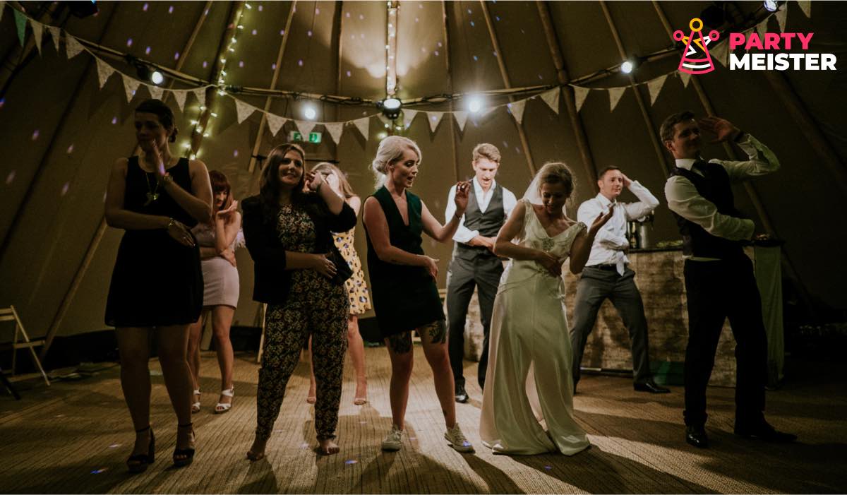 a group of people at a wedding, dancing