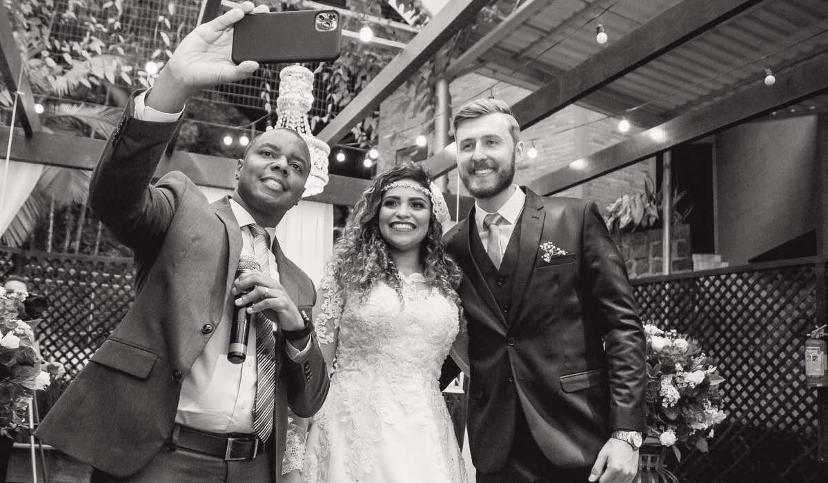 Black and white image of three wedding guests taking a selfie