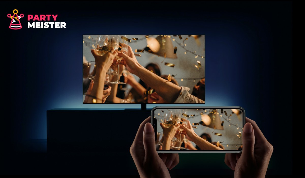 Two hands holding a smartphone that's displaying an image of people clinking wine glasses. The image is beamed to a TV. There's a PartyMeister logo in the top-left corner