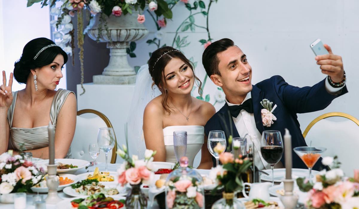 Wedding guests take a selfie at a table