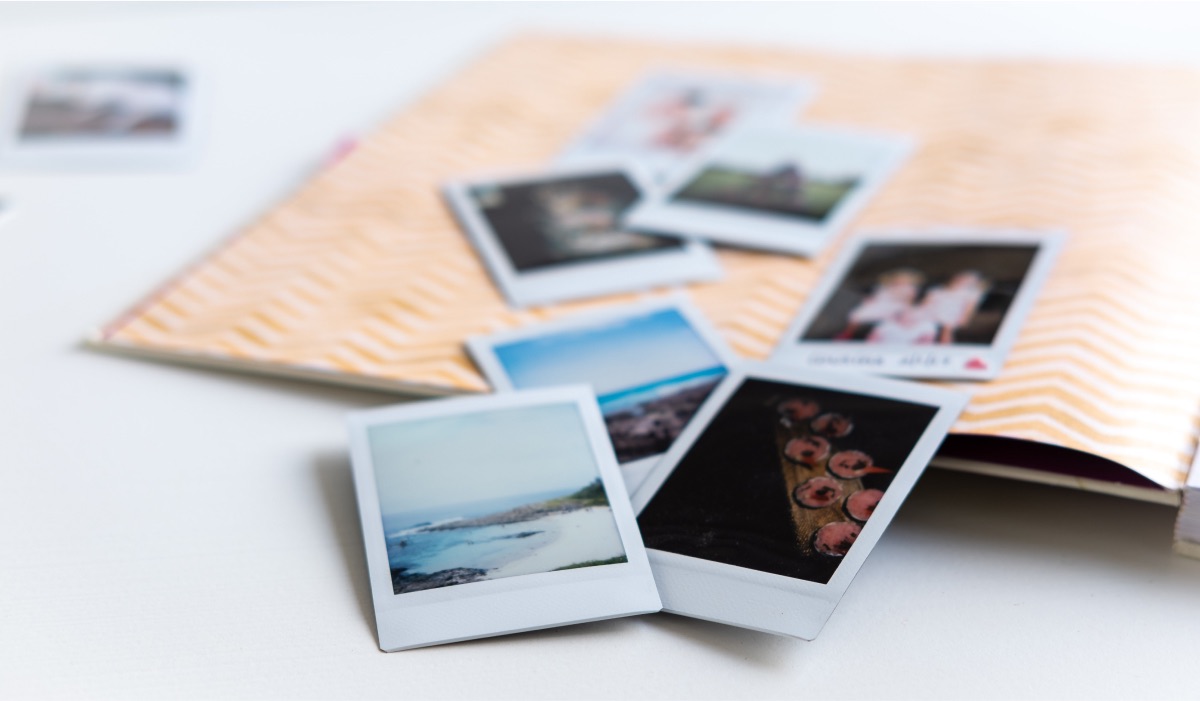 Several Polaroid pictures laying on a notebook