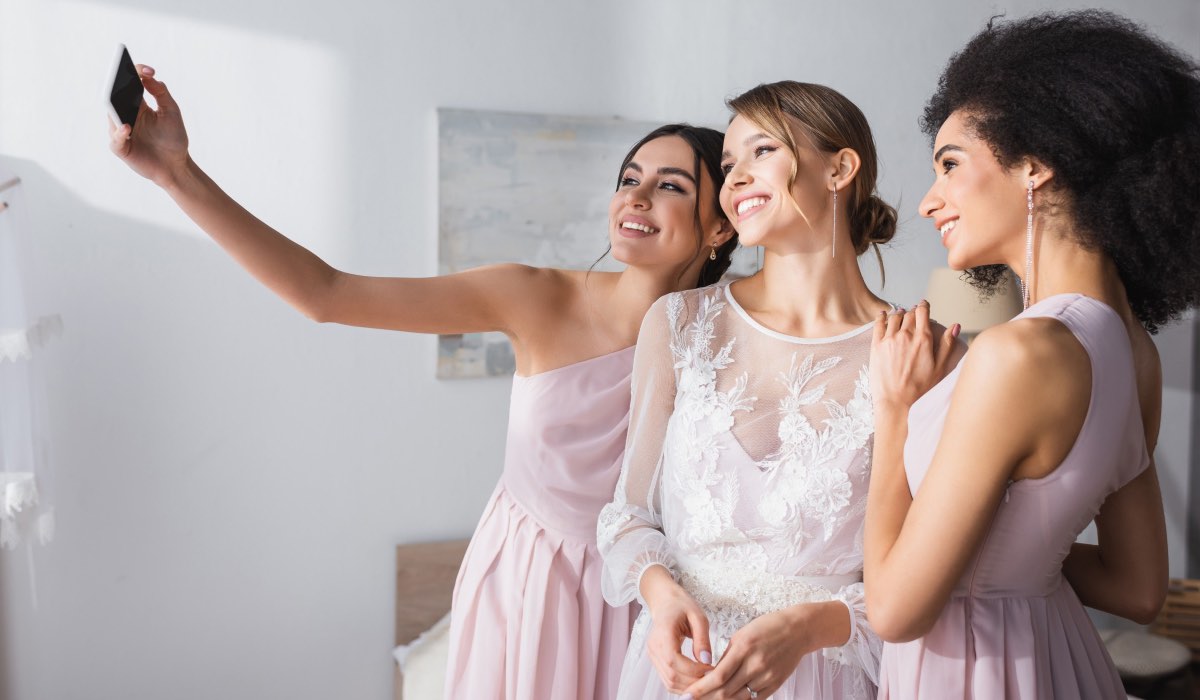 Three wedding guests are taking a selfie indoors