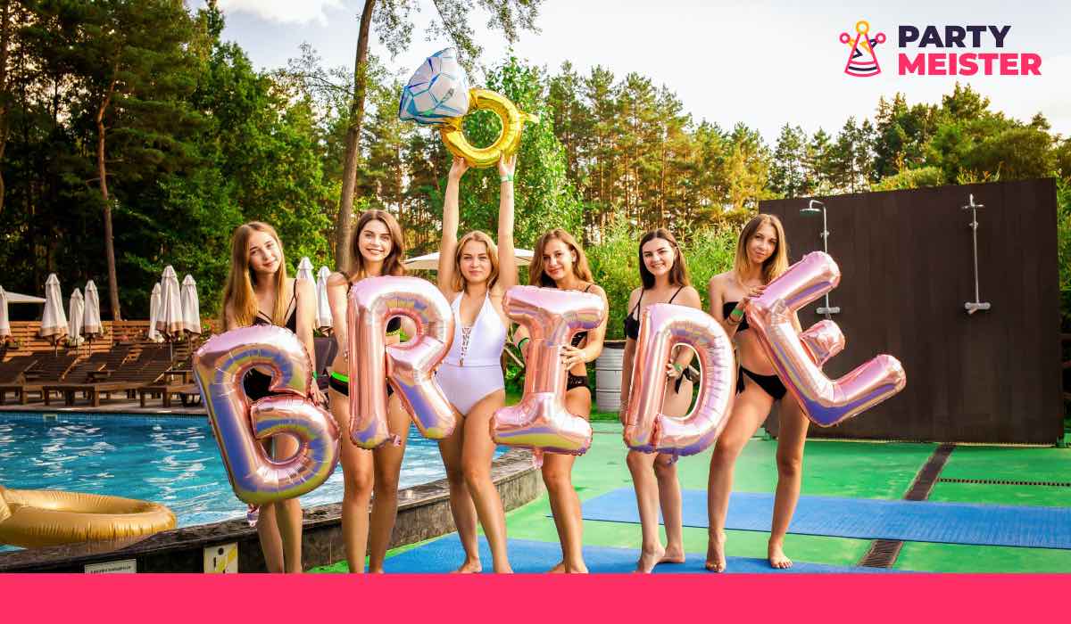 Bachelorette party attendants by a pool, each holding one balloon letter making up the word "Bride"