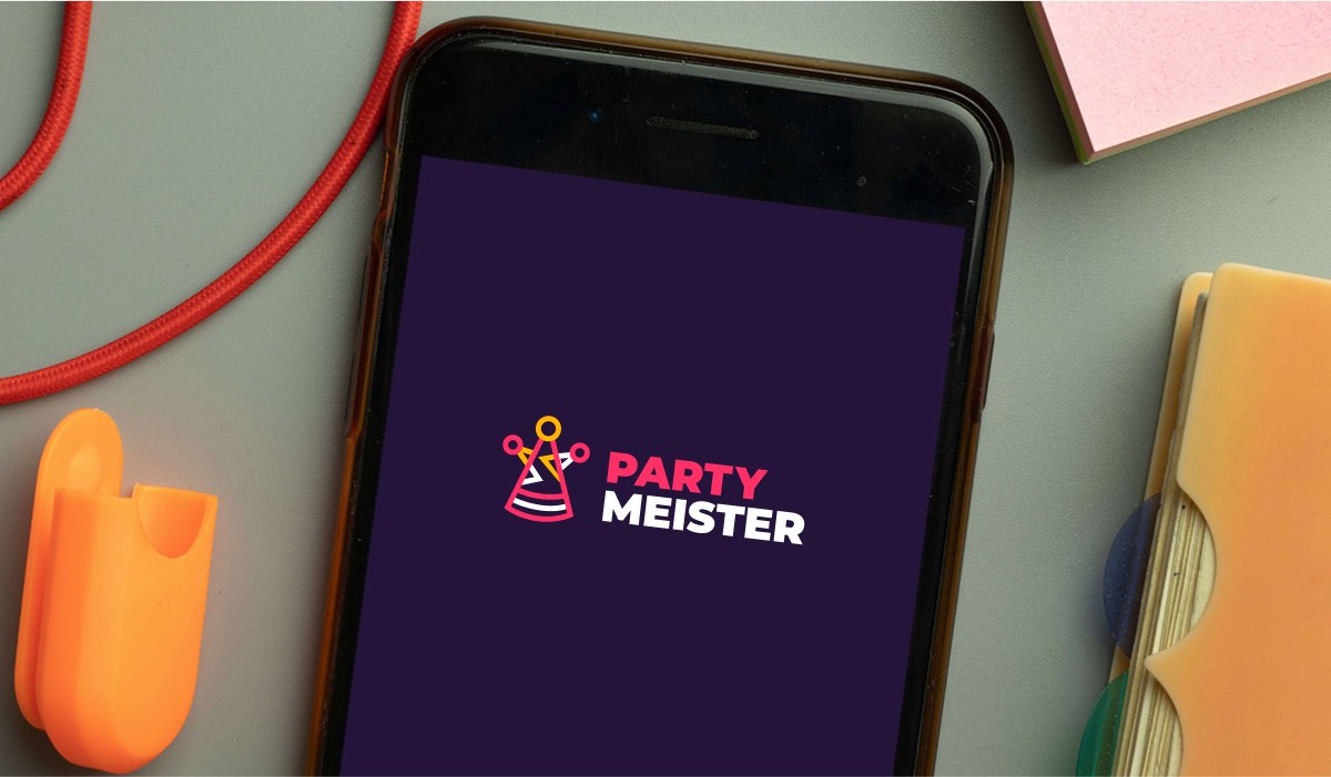 PartyMeister logo on an iPhone, a cable and a notebook